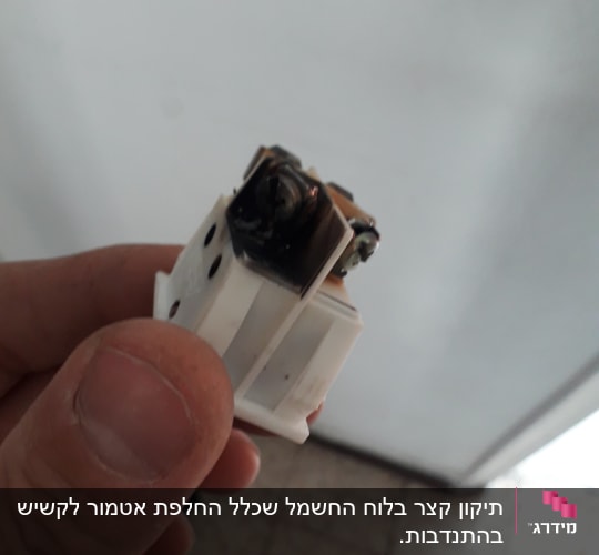 שקע חשמלי עם סימני שריפה ביד חשמלאי